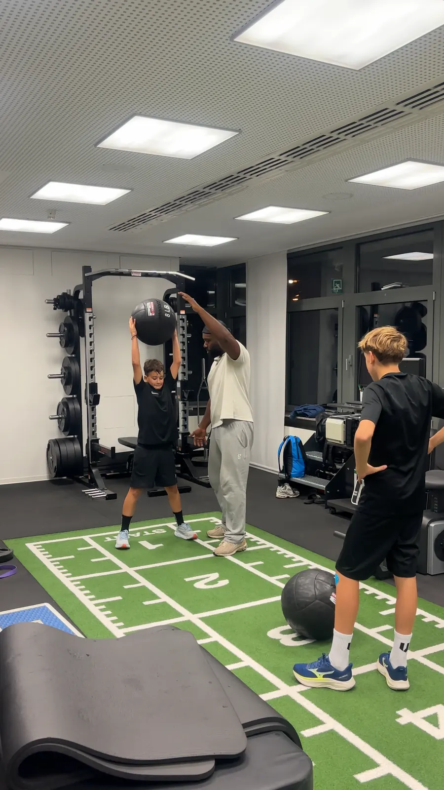 Norberto Fernandez korrigiert einen Spieler beim Überkopfwurf mit dem Medizinball