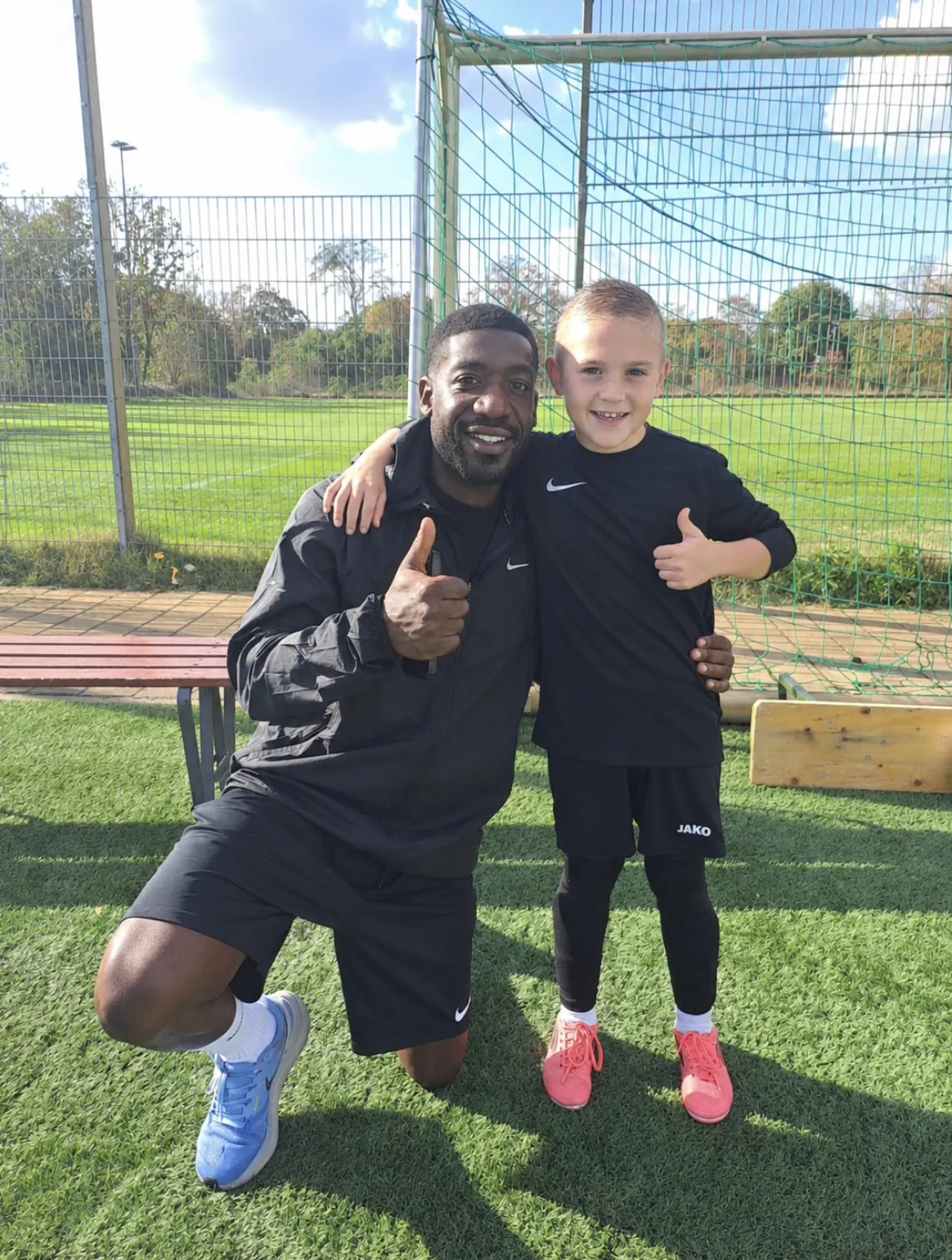 Norberto Fernandez und Kalle zeigen den Daumen hoch vor dem Tor auf dem Trainingsplatz